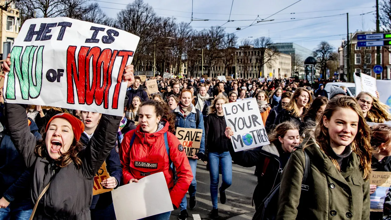 Een groep jongeren demonstreert. Ze houden protestborden omhoog