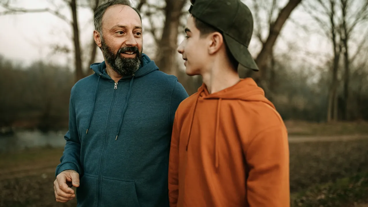 Man met baard en jonge lopen naast elkaar