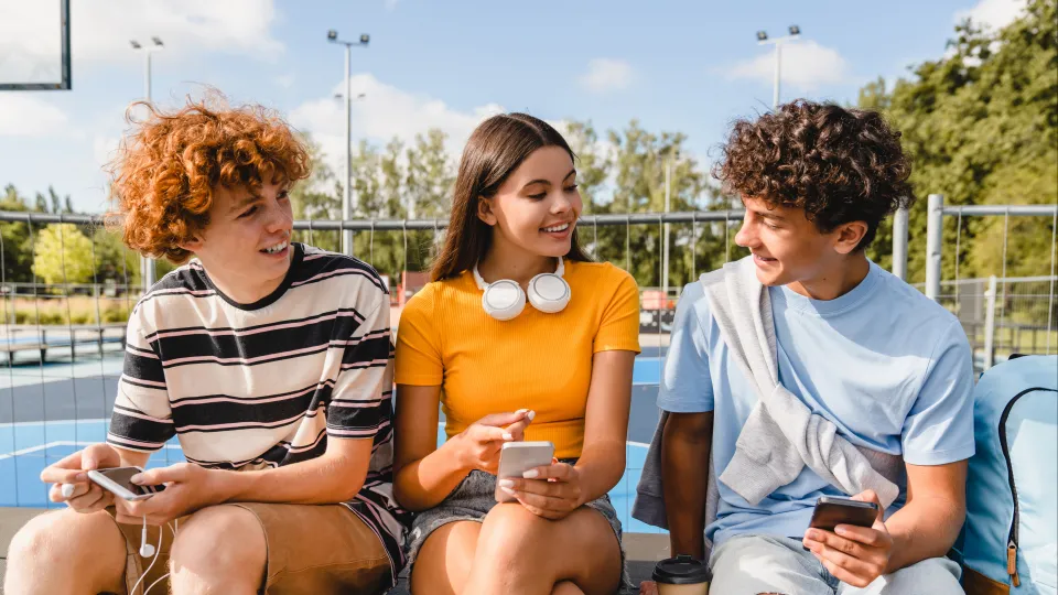 Drie kinderen zitten buiten naast elkaar