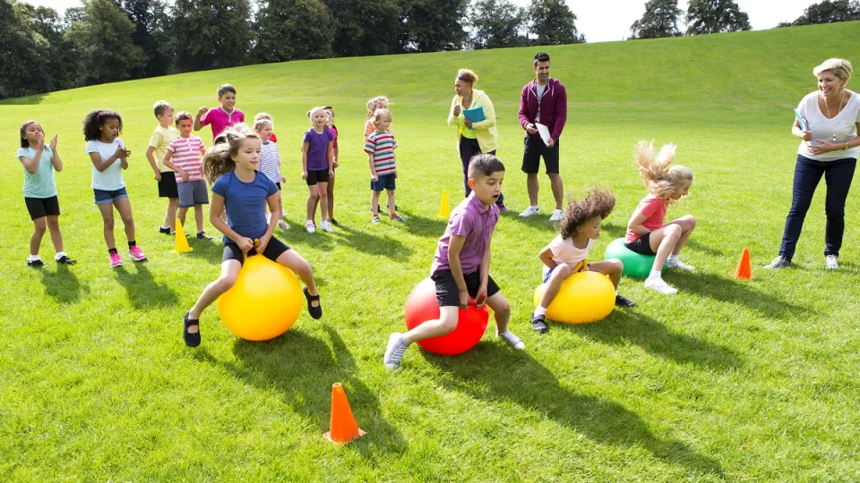 Groep jonge kinderen spelen op een grasveld