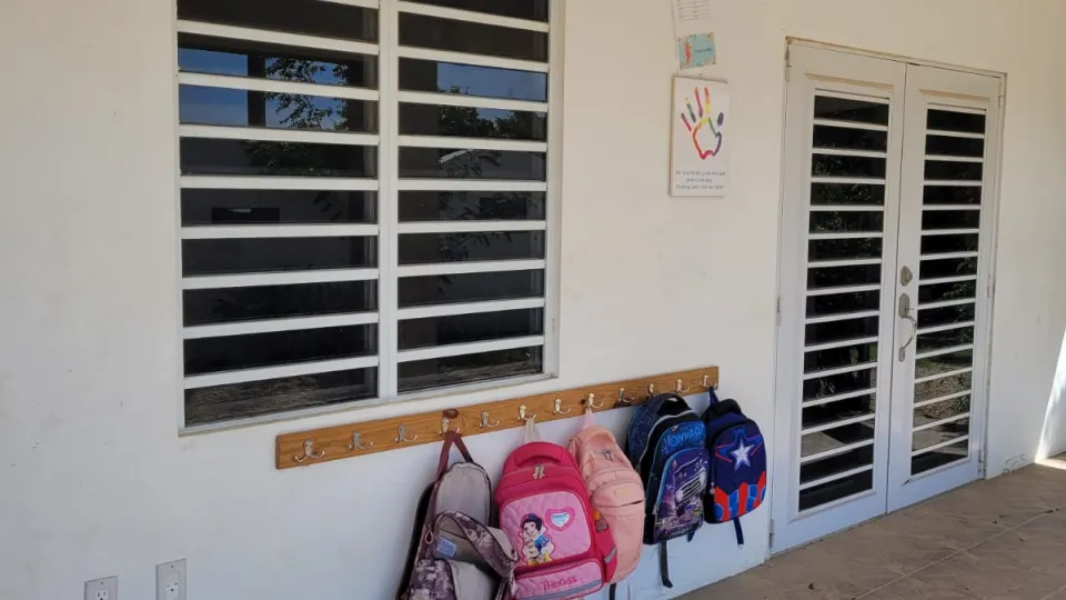 Tassen van schoolkinderen hangen aan de muur op Bonaire