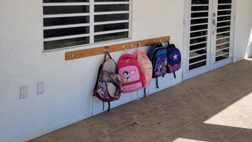 Tassen van schoolkinderen hangen aan de muur op Bonaire