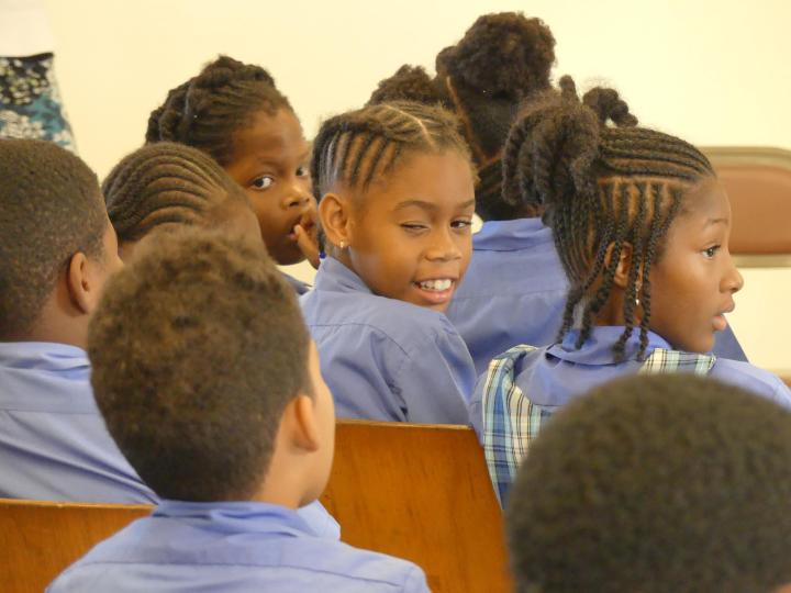 Klas met kinderen in Caribisch Nederland. Ze dragen een blauw schooluniform